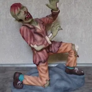 Zombie en mauvaise posture, un genoux au sol, il essaie d'éviter les coups.