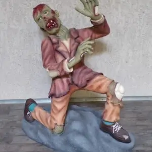 Zombie en mauvaise posture, un genoux au sol, il essaie d'éviter les coups.